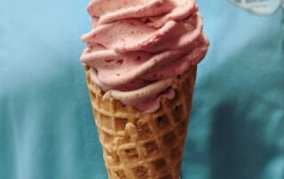 Strawberry ice cream served in a waffle cone